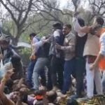 भाजपा कार्यकर्ता AI Summit विरोध में पोस्टर ले जाते हुए