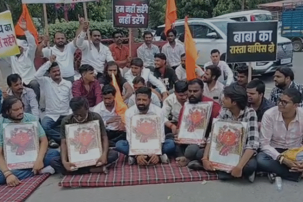 Devotees and villagers sitting on a peaceful protest at Collector Chauraha with placards supporting Baba Bhootnath Mandir, highlighting the Indore and Rangwasa location.