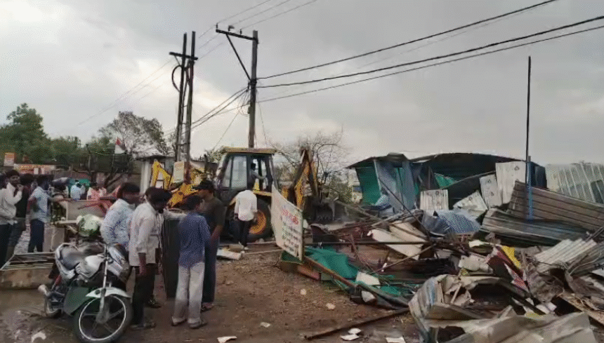 Revenue officials, municipal corporation team and police personnel conducting encroachment removal action in Bank Gram, Malharganj, with government land clearance visuals.